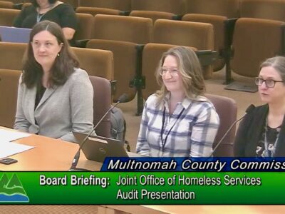 Nicole Dewees, Mandi Hood and Jennifer McGuirk sit at dais in board room. Text says 